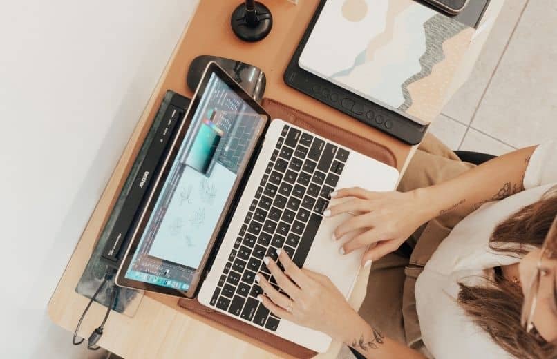 girl typing on white laptop