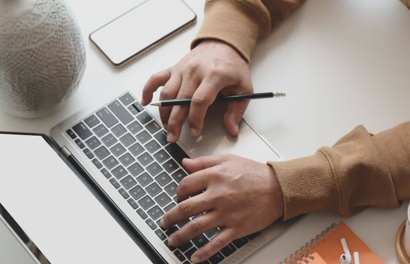 man typing on white computer