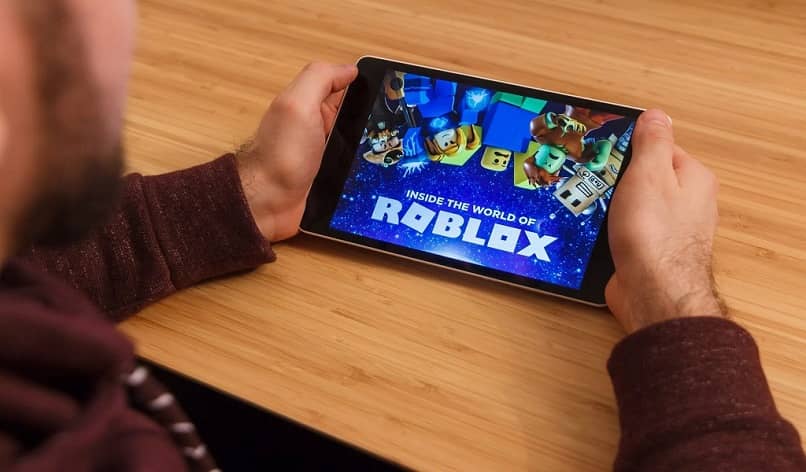 man playing roblox on tablet