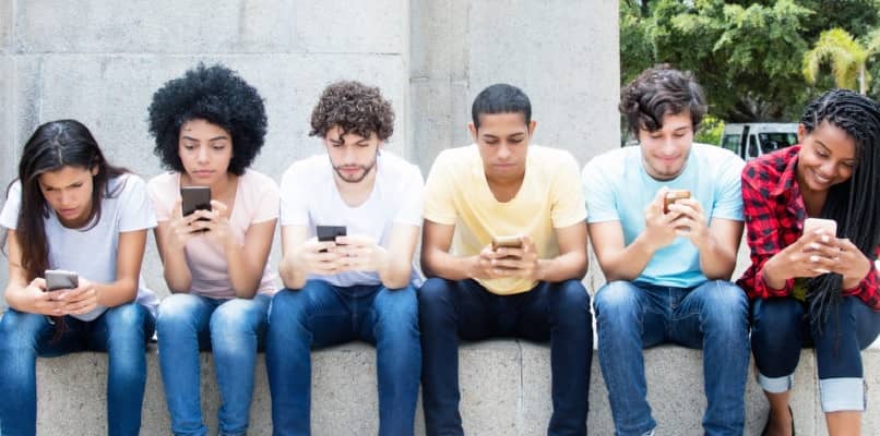 Group of young people looking at their mobile phones