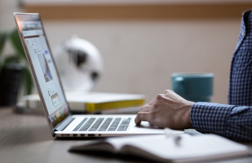 man typing on laptop