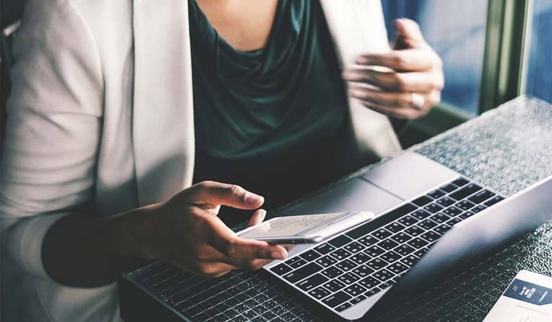 woman using laptop and mobile phone