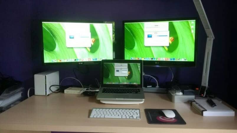 three mac monitors on table