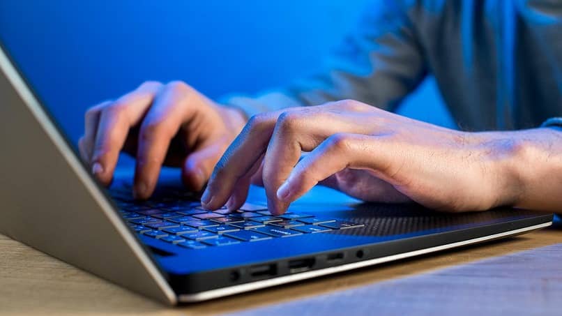 man typing on laptop